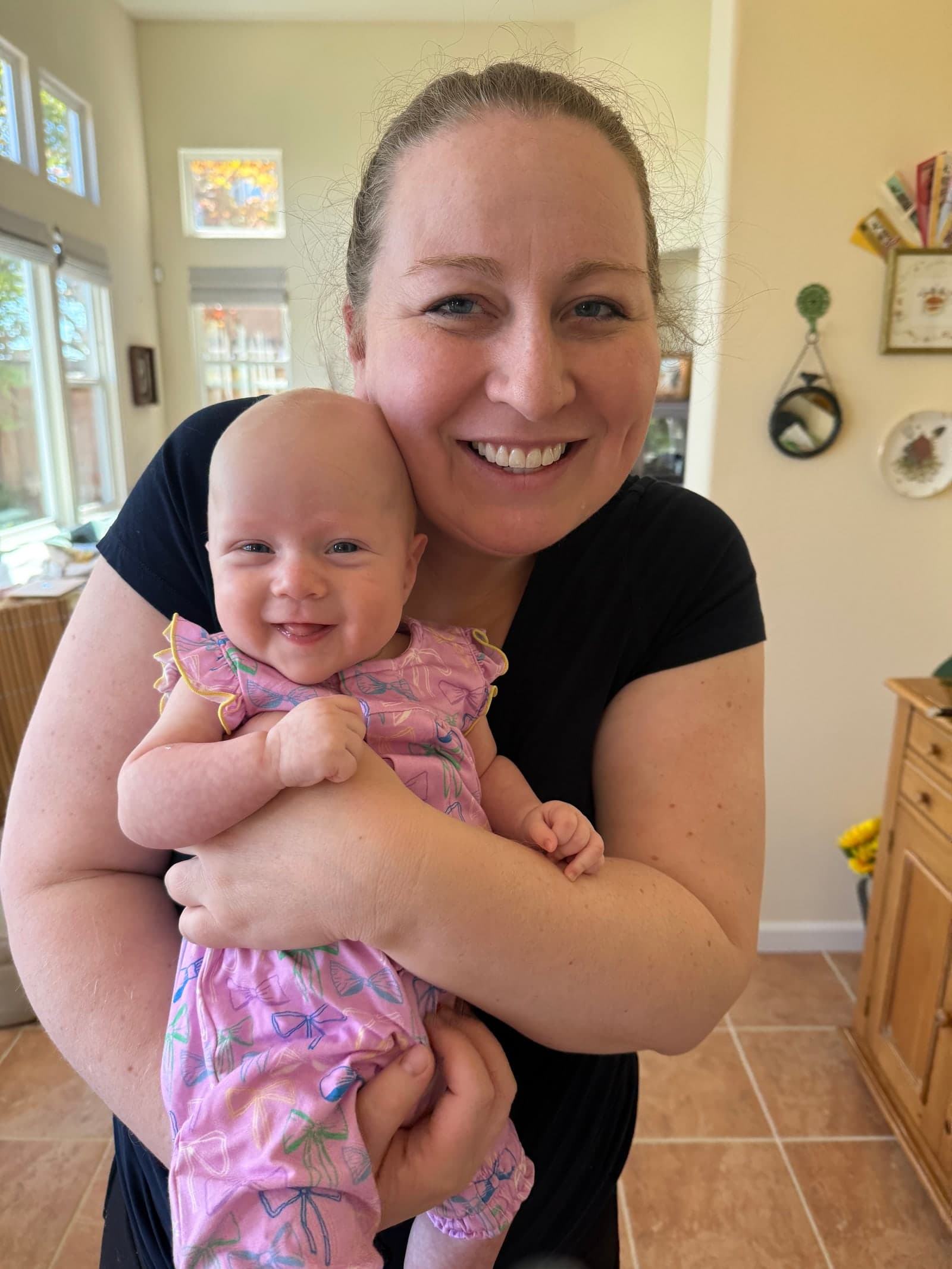 Andrea holding Chloe and smiling at home
